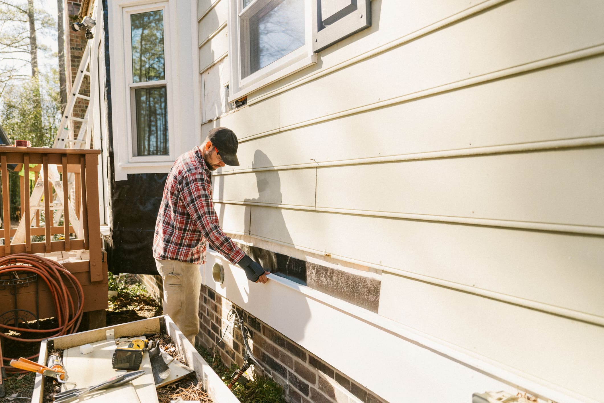 Man painting the exterior wall of a house.